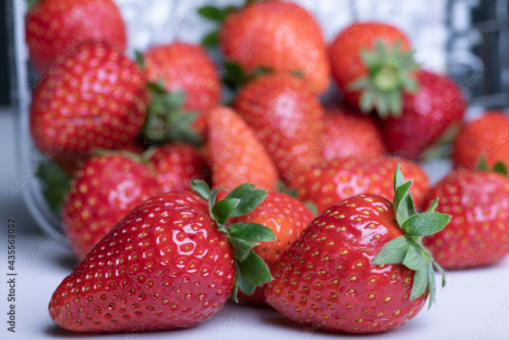 Macro photograph of a plastic box full of strawberries on white. selective focus Macro photograph of a plastic box full of strawberries on white. selective focus
