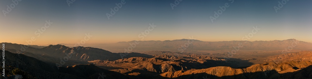Panorama shot bare desert hills and valley at morning sun and dust in joshua tree national park in america
