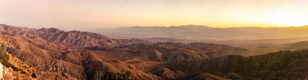 Paorama shot of bare desert hills and valley in joshua tree national park at last rays of sunset in america