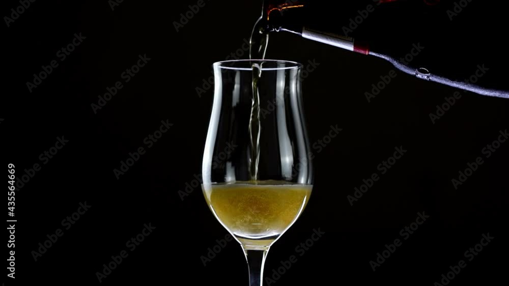 Pouring beer from the bottle into a rotating glass 360 degrees. Pouring beer from the bottle into a rotating glass 360 degrees.