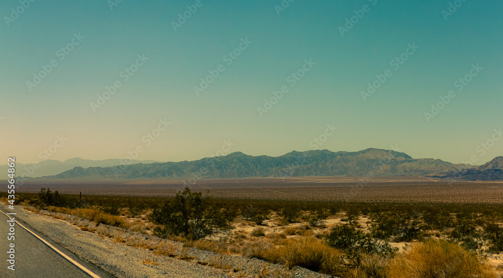 Rocky hills behind flat american desert with blue sky
