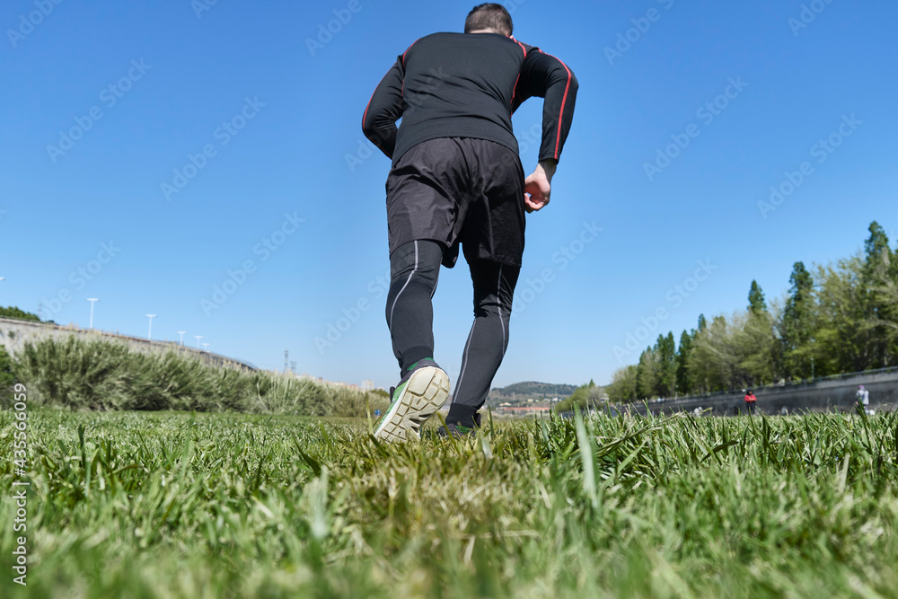 athletic man running on a sunny morning in a green city park athletic man running on a sunny morning in a green city park
