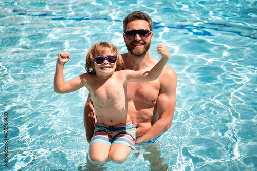 Family in swimming pool. Father and son on summer vacation. Pool party. Child with dad playing in swimming pool.