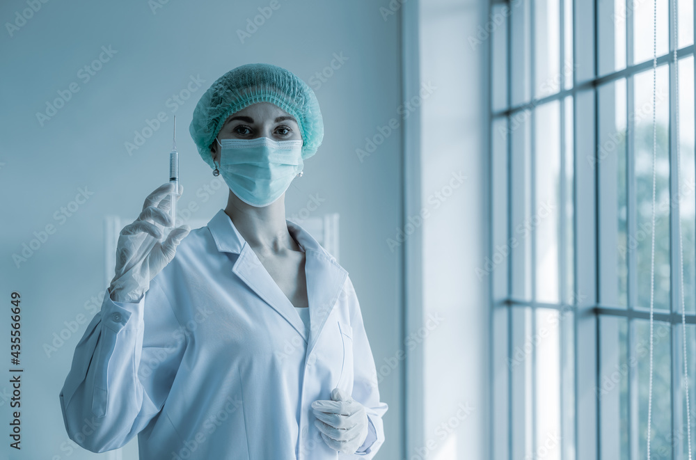 Fototapeta premium Doctor wearing face mask hat and glass, hold coronavirus (covid-19) vaccine for injection people ,Vaccine is concept of fight against coronavirus healthcare and medical.