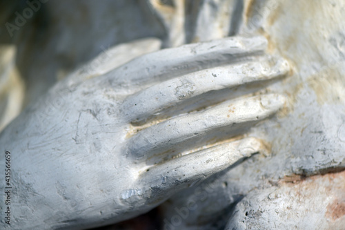 A hand on the breast. Partial view of an old sandstone-sculpture in Spain. photo