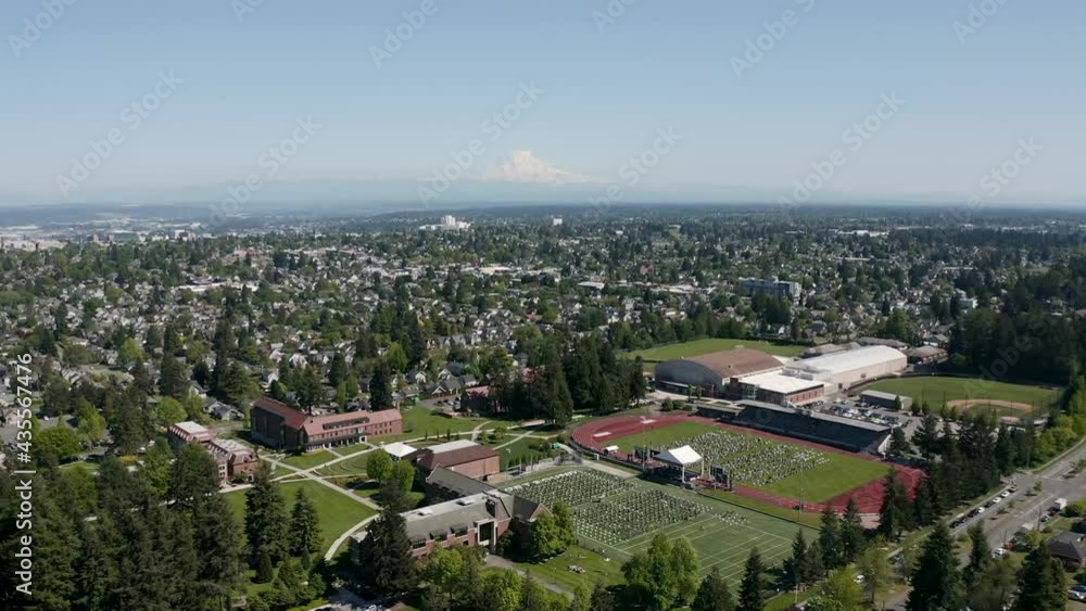 Aerial View Of City Buildings And Graduation Ceremony In The Field Of University of Puget Sound In Tacoma, Washington. Aerial View Of City Buildings And Graduation Ceremony In The Field Of University of Puget Sound In Tacoma, Washington.