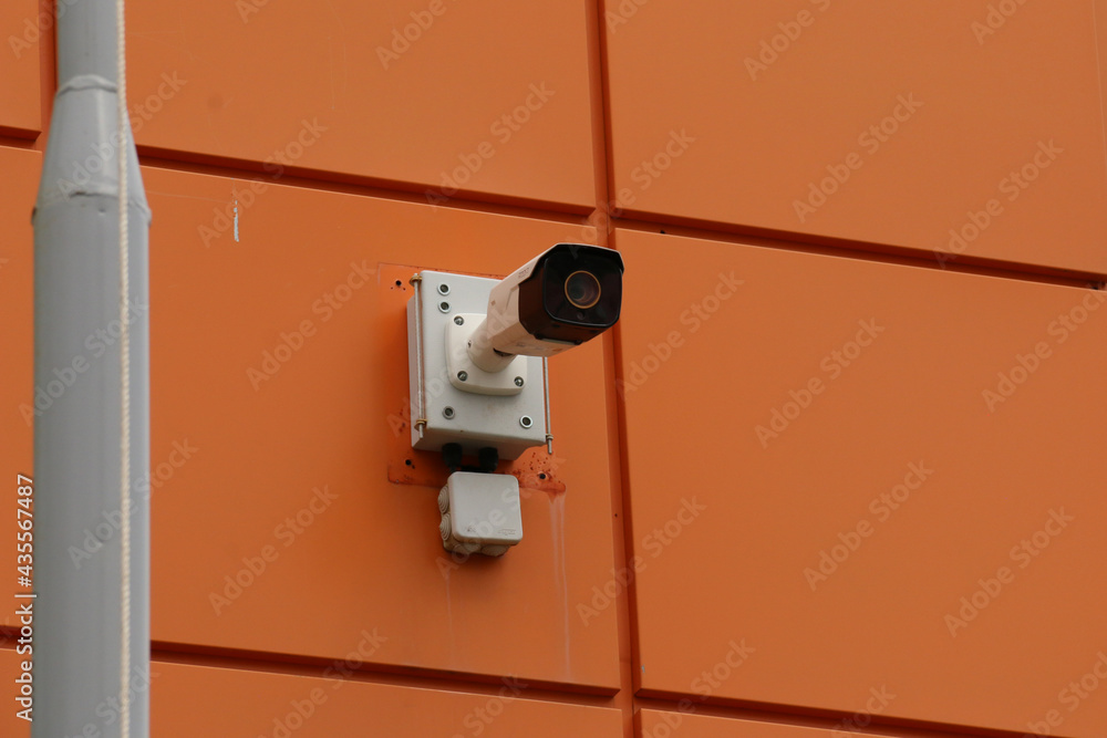 CCTV camera mounted on the wall. A large surveillance camera is attached to the cladding of the building.