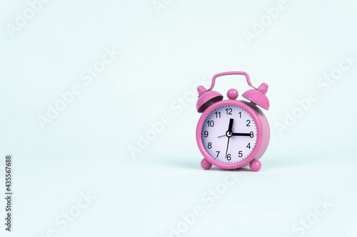 Pink alarm clock on white background
