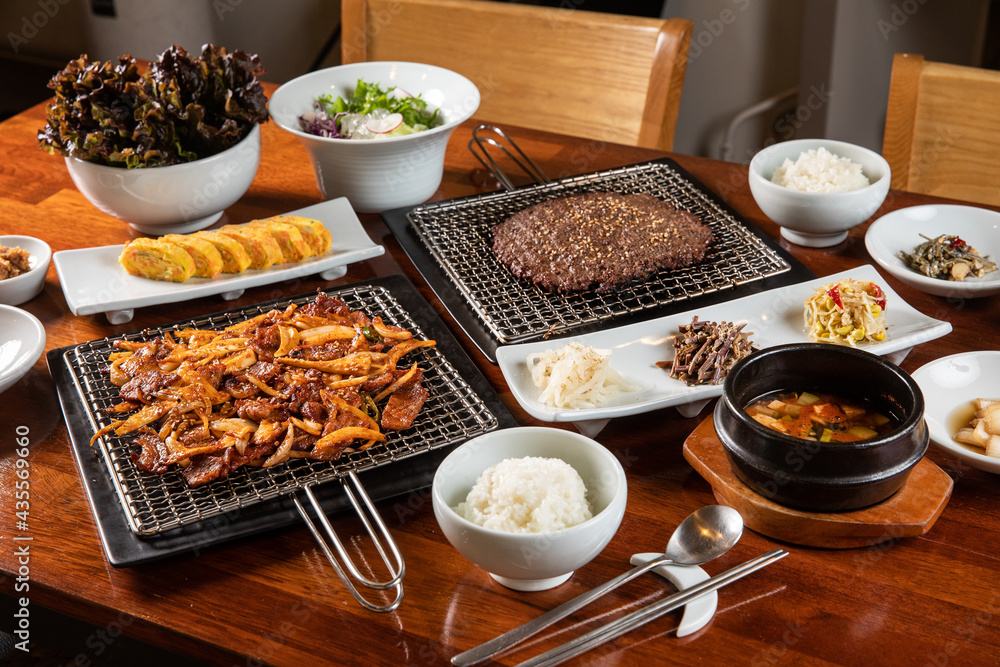 hanu bulgogi and pork Bulgogi with rolled eggs, rice, kimchi , salad , tofu soup on a table hanu bulgogi and pork Bulgogi with rolled eggs, rice, kimchi , salad , tofu soup on a table