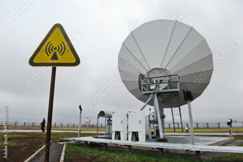 Almaty, Kazakhstan - 11.20.2015 : A sign warning of a powerful electromagnetic field and antennas for receiving data from the KAZSAT satellite
