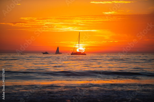 Sunset at the sea. Yacht sailing in an open sea at sunset. Sunset in the sea with beautiful clouds. Sunrise ocean seascape.