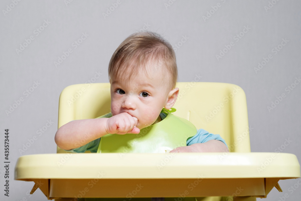 little child eats on gray background little child eats on gray background