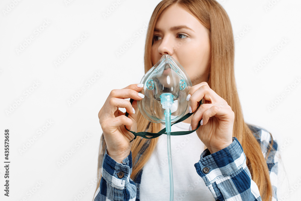 Young woman holding oxygen mask to treat breathing problem, Covid-19 attack lungs on white background Young woman holding oxygen mask to treat breathing problem, Covid-19 attack lungs on white background