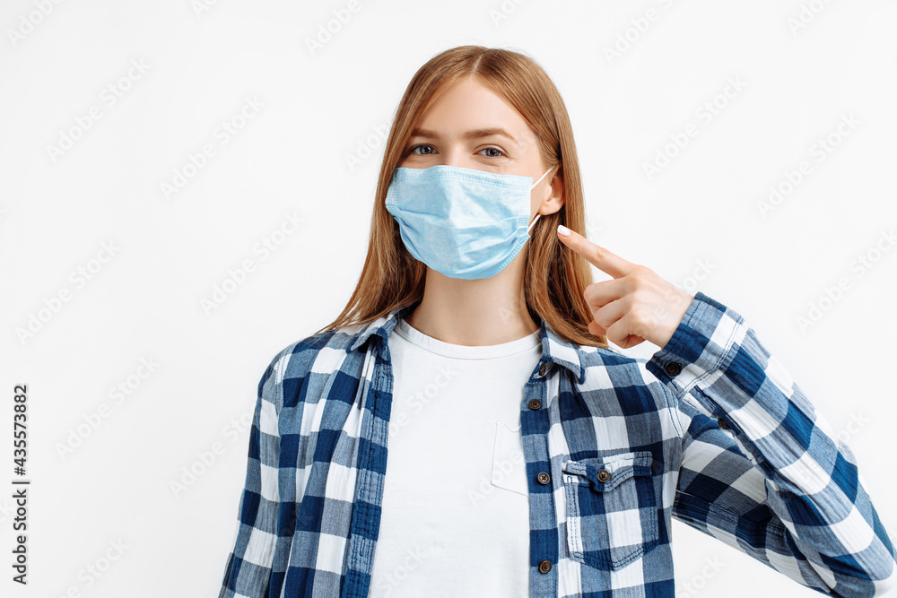 Young woman wearing protective medical mask on face, on white background, health, safety and pandemic concept