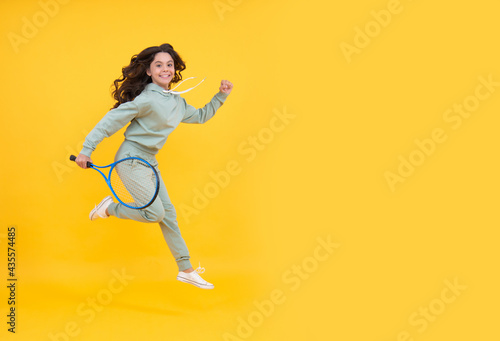 happy energetic child jump with tennis racquet running to success, copy space, sport shopping sale.