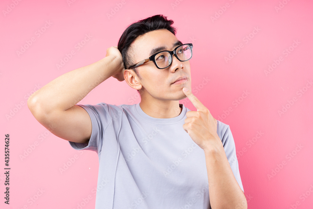 Portrait of Asian man posing on pink background with many expression Portrait of Asian man posing on pink background with many expression