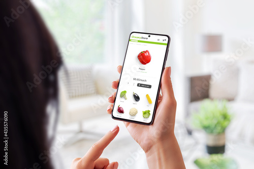 Woman buys online at a grocery store with smart phone concept