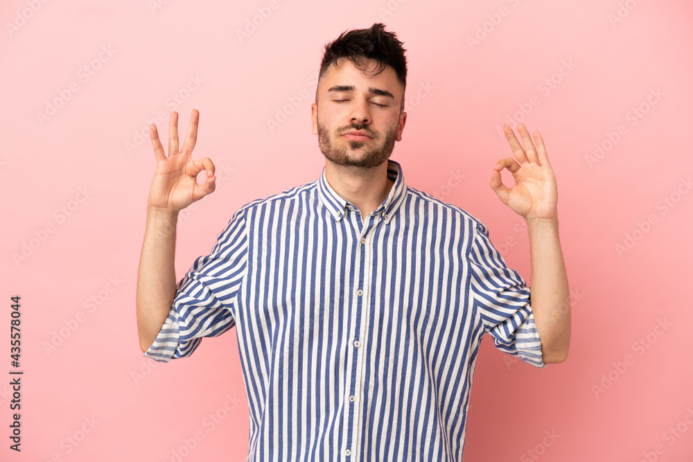 Young caucasian man isolated on pink background in zen pose Young caucasian man isolated on pink background in zen pose