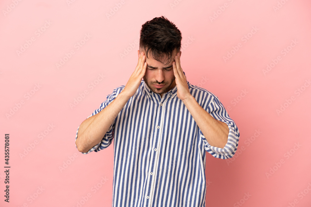 Young caucasian man isolated on pink background with headache Young caucasian man isolated on pink background with headache