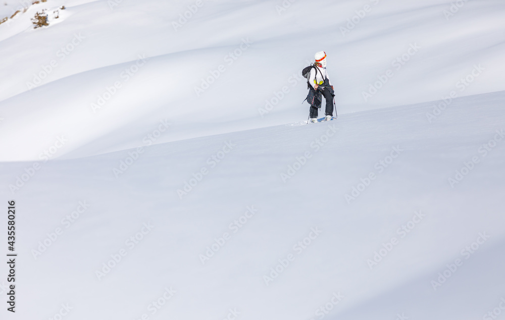 Skier walks on fresh snow uphill