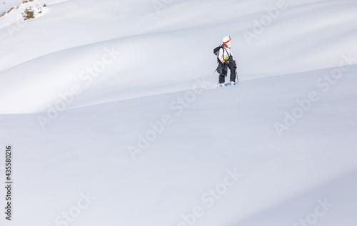 Skier walks on fresh snow uphill photo