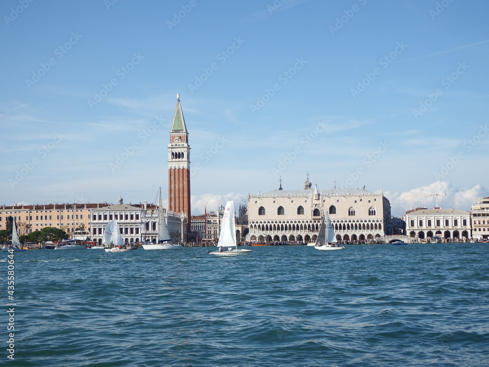 The Dogenpalace and Church of San Marco at the Venetian Lagoon from an Outstanding View with  white sail boats on a Sunny Day in Italy