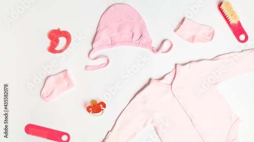 Baby background. Clothes for small girl with socks. Accessories for newborn on white background. Top view. Copy space