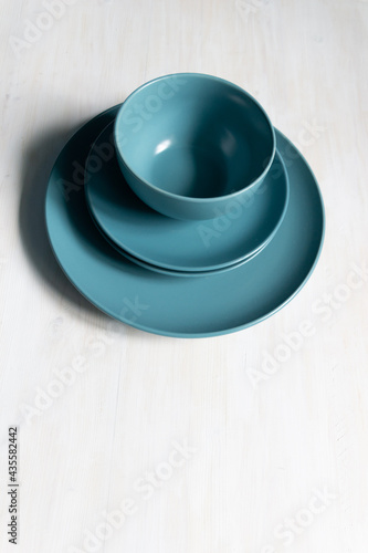 empty blue-green plates and bowl on white  table