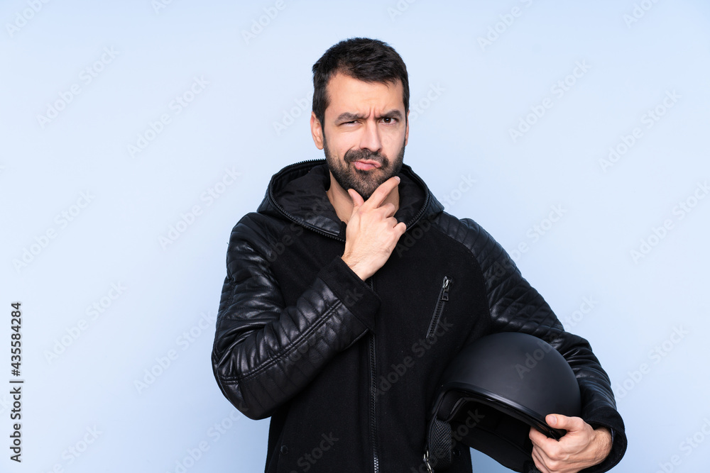 Man with a motorcycle helmet over isolated background thinking Man with a motorcycle helmet over isolated background thinking