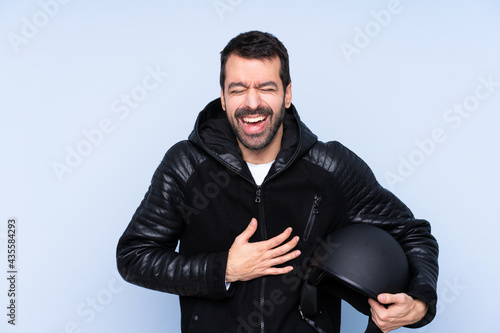 Man with a motorcycle helmet over isolated background smiling a lot