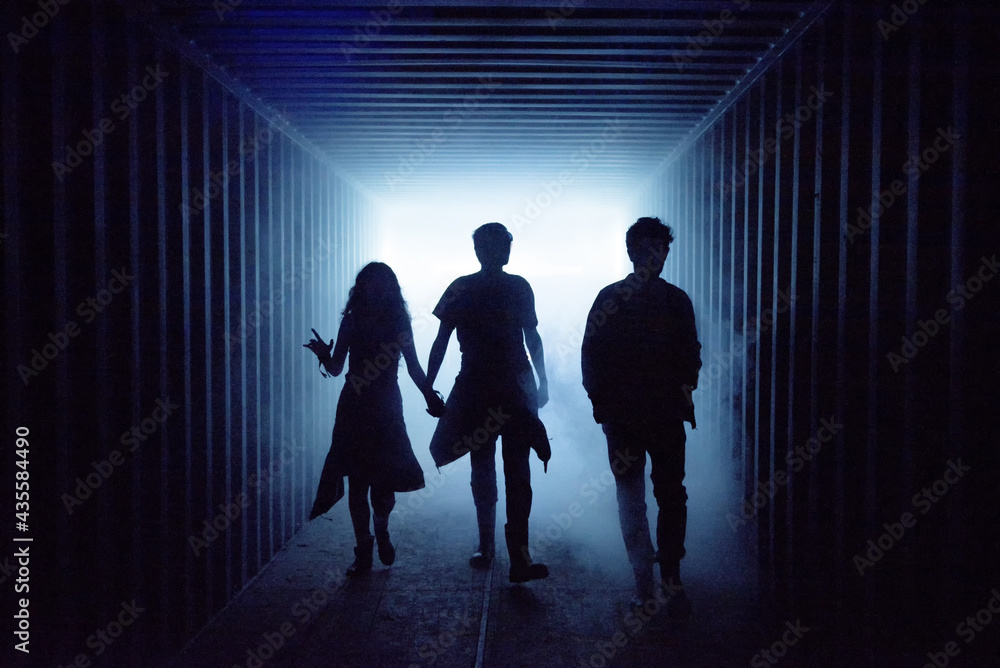 Silhouette of people walking in a dark subway tunnel Silhouette of people walking in a dark subway tunnel