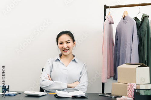 Asian entrepreneur sits on a chair and smiles, showing confidence. photo