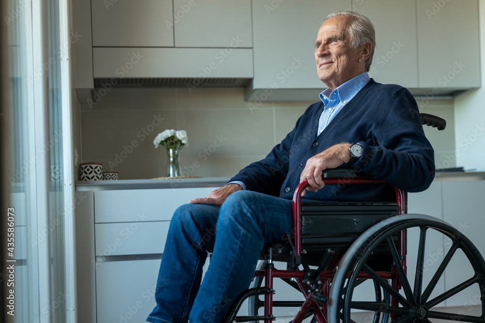Cinematic shot of elderly disabled senior man in wheelchair is looking through window in the morning at home. Concept of life, pensioner, grandparents, retirement, boarding house, hope, handicap Cinematic shot of elderly disabled senior man in wheelchair is looking through window in the morning at home. Concept of life, pensioner, grandparents, retirement, boarding house, hope, handicap