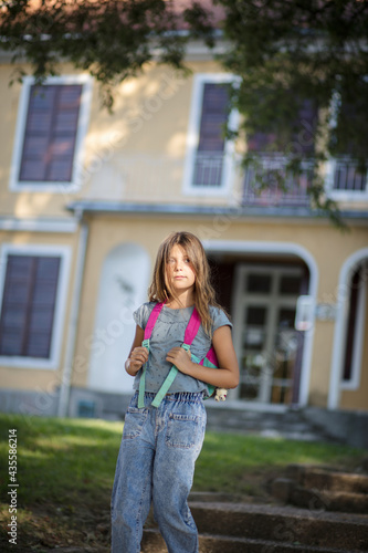 The end of the school day. Little girl with school bag.