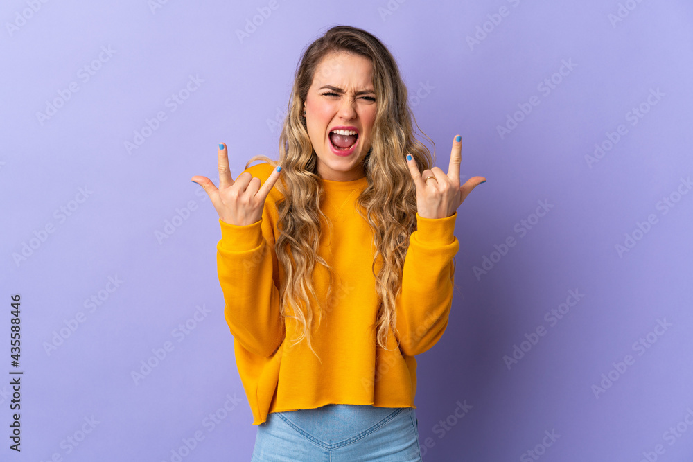 Young Brazilian woman isolated on purple background making horn gesture Young Brazilian woman isolated on purple background making horn gesture