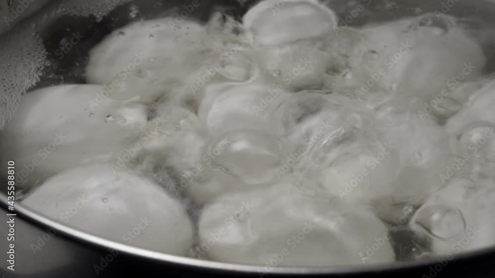 White Chicken eggs boiling in stainless steel pan, closeup White Chicken eggs boiling in stainless steel pan, closeup