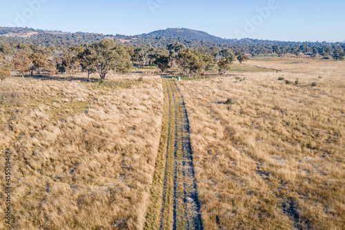 Frosty dirt road through the grass - aerial, Jerrabomberra West Nature Reserve, ACT, May 2021