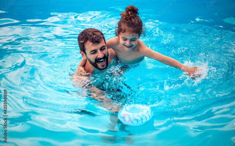 Father and son playing together in the swimming pool. Father and son playing together in the swimming pool.