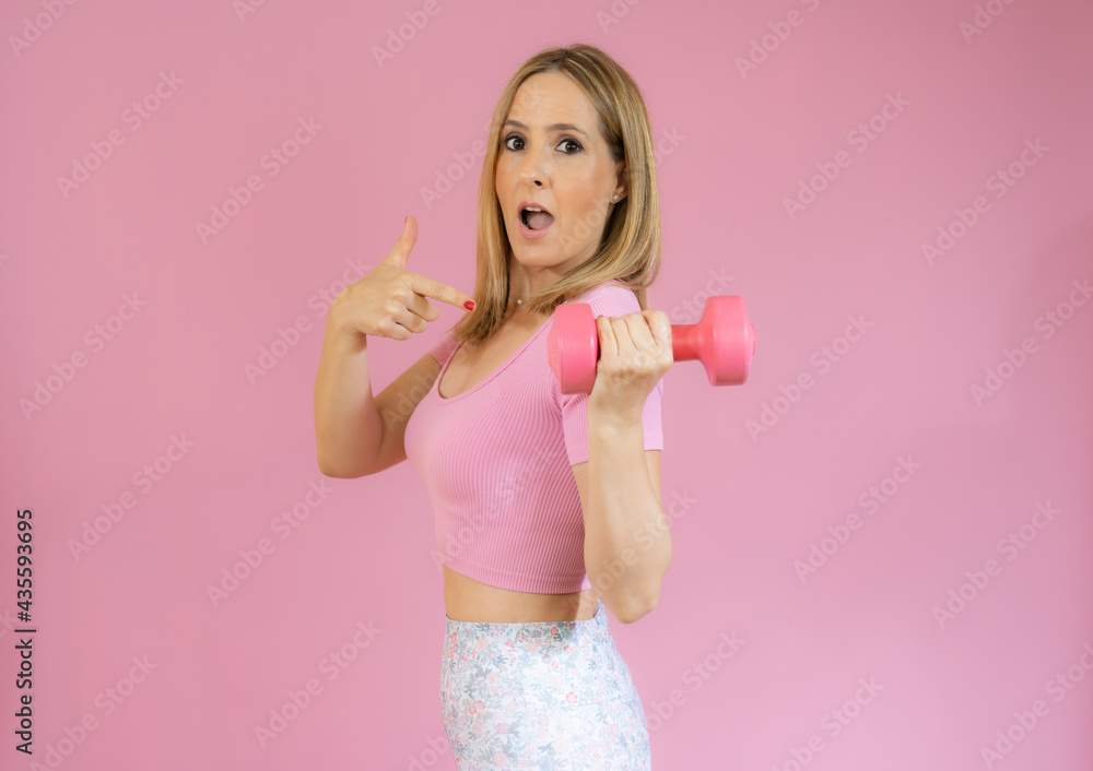 Cute athletic woman in sportswear with yoga mat isolated on pink background Cute athletic woman in sportswear with yoga mat isolated on pink background