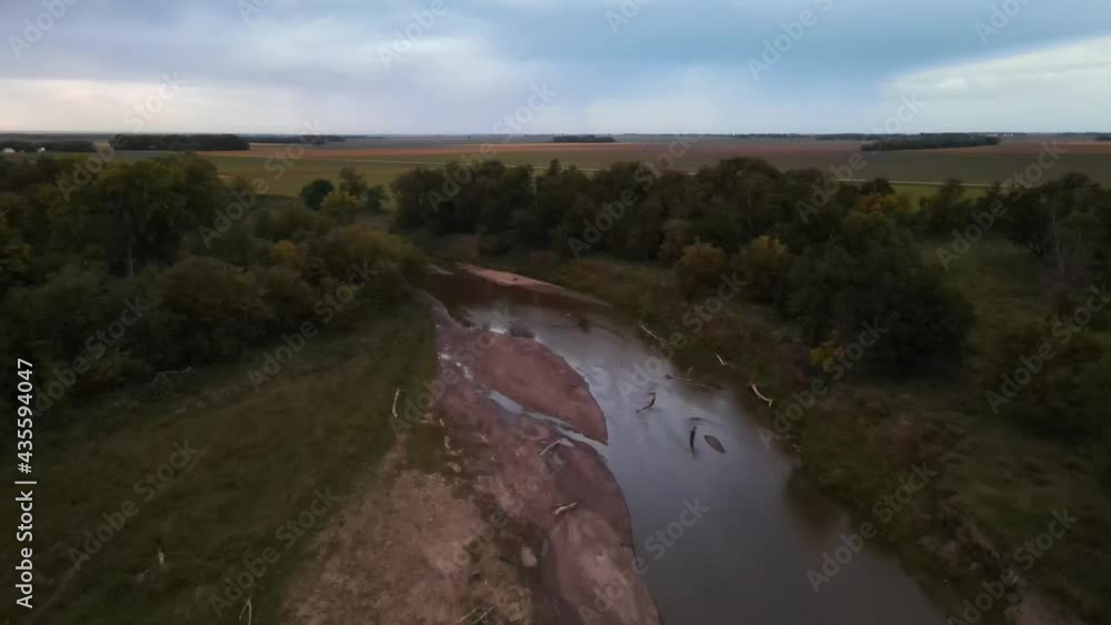 Aerial flyover of still murky, dirty river surrounded by lush greenery and cultivated fields in rural North Dakota. Daytime, summertime, outdoors. Aerial flyover of still murky, dirty river surrounded by lush greenery and cultivated fields in rural North Dakota. Daytime, summertime, outdoors.