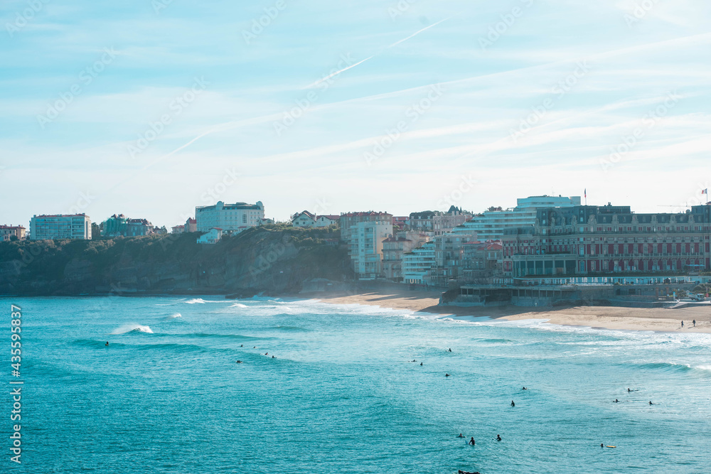 Surfeurs à la grande plage de Biarritz avec le phare
