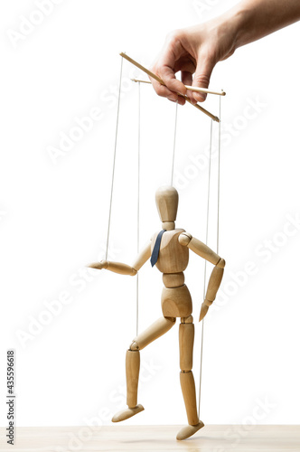The human hand with marionette on the strings. Concept of control. On white.