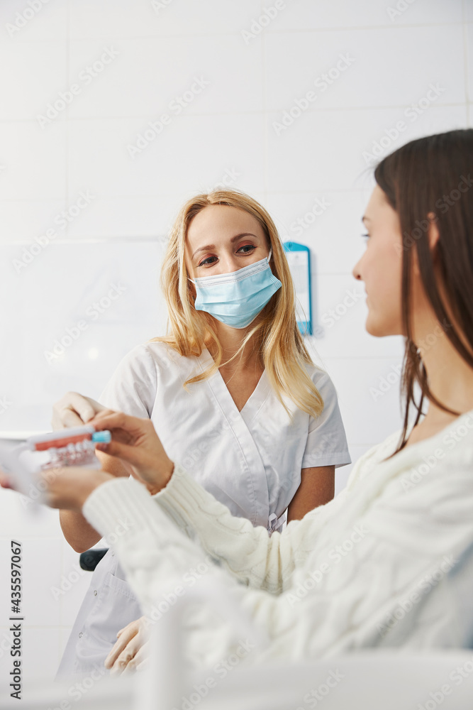 Friendly orthodontist taking away toothbrush from patient Friendly orthodontist taking away toothbrush from patient