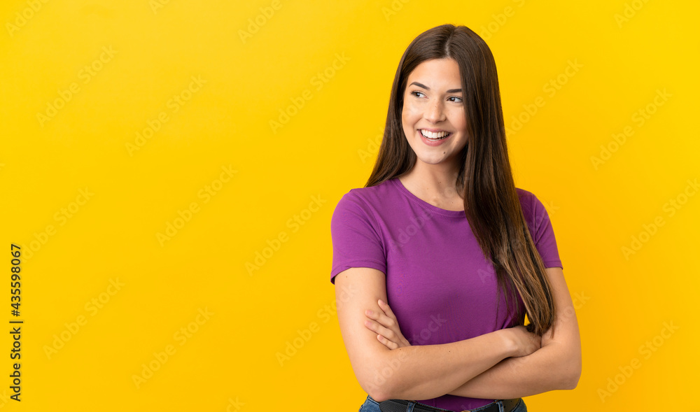 Obraz premium Teenager Brazilian girl over isolated yellow background happy and smiling