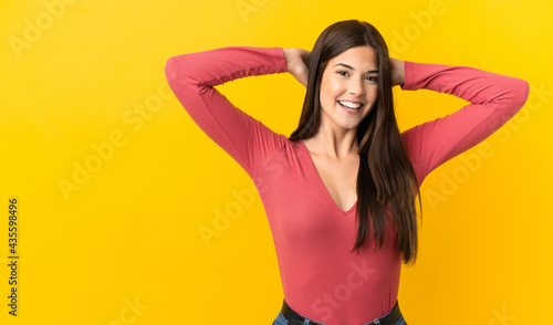 Teenager Brazilian girl over isolated yellow background laughing