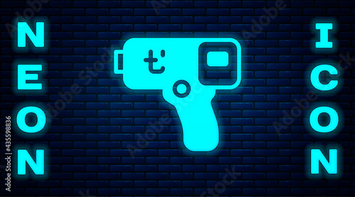 Glowing neon Digital contactless thermometer with infrared light icon isolated on brick wall background. Vector