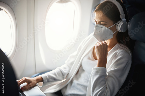 Calm female passenger of the plane using modern laptop
