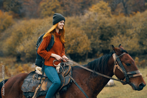 cheerful woman hiker riding a horse adventure mountains fresh air