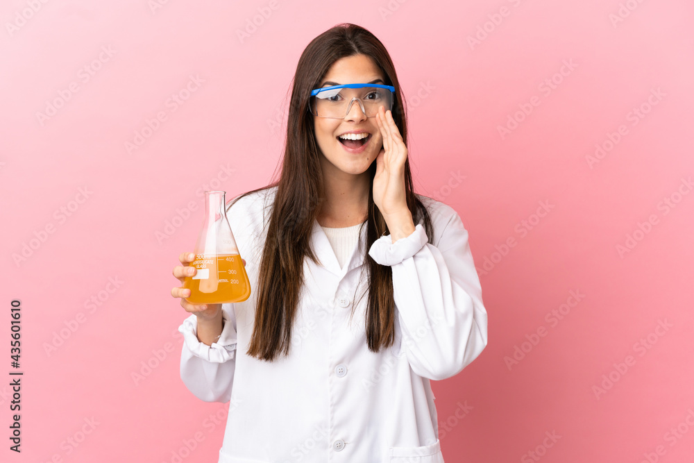 Young scientific girl over isolated pink background shouting with mouth wide open Young scientific girl over isolated pink background shouting with mouth wide open
