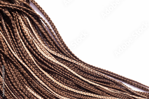 Thin brown African braids on a white background. Hair close-up braided in pigtails dreadlocks, afro style